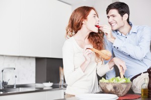 Couple making a salad and laughing
