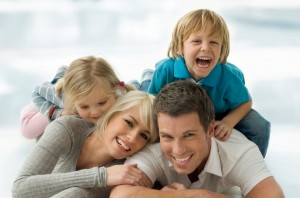 Mom, dad, little girl, and little boy laughing and playing