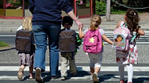 Four kids with backpacks walking to school