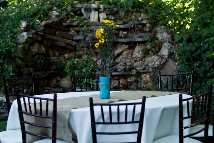 Vase on a table filled with branches and yellow flowers