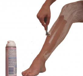 leg with shaving cream being shaved