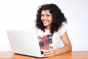 Teenage girl smiling in front of a laptop