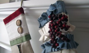 The tops of two Christmas stockings hanging on a mantle