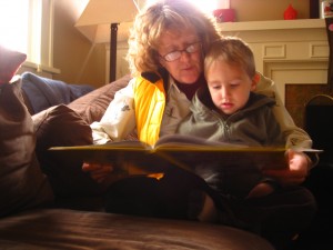 A little boy readin with his grandma