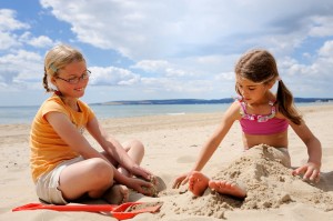 Two girls playing in the sand at the beach
