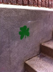 shamrock painted on a concrete wall by stairs